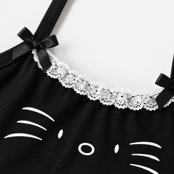 Close-up detail of lace trim girls top with satin ribbon bows and cat graphic print.